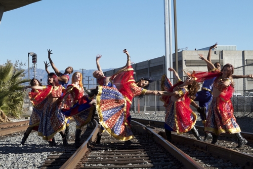 Blue13 dancers pose for a dancing shot on some railroad tracks in traditional Indian dress
