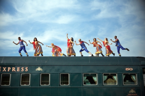 Two Blue13 dancers pose for a running photo on top of a decommissioned train car